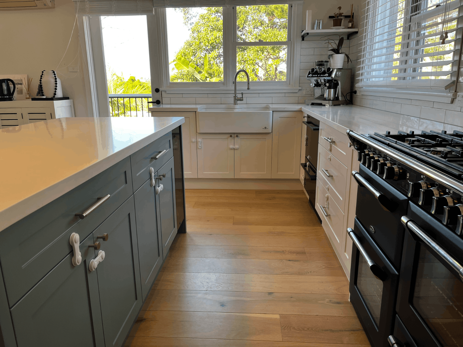 Red Hot Kitchens bright modern kitchen with island, farmhouse sink, gas stove; perfect for stylish makeovers.