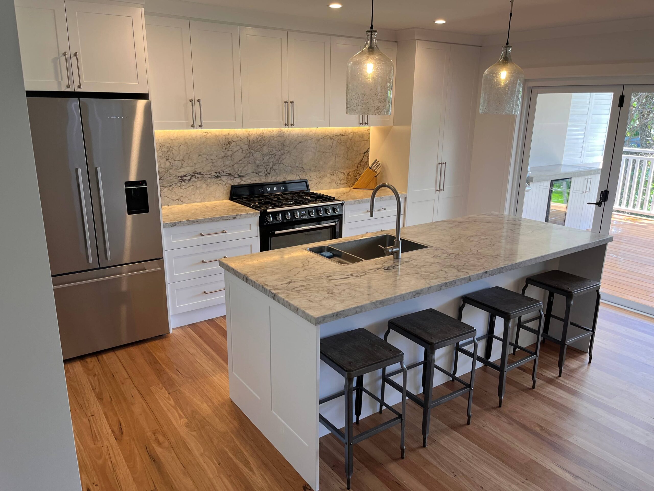 Modern kitchen renovation featuring white cabinets, marble counters, and stainless appliances by Red Hot Kitchens in Collaroy Plateau.
