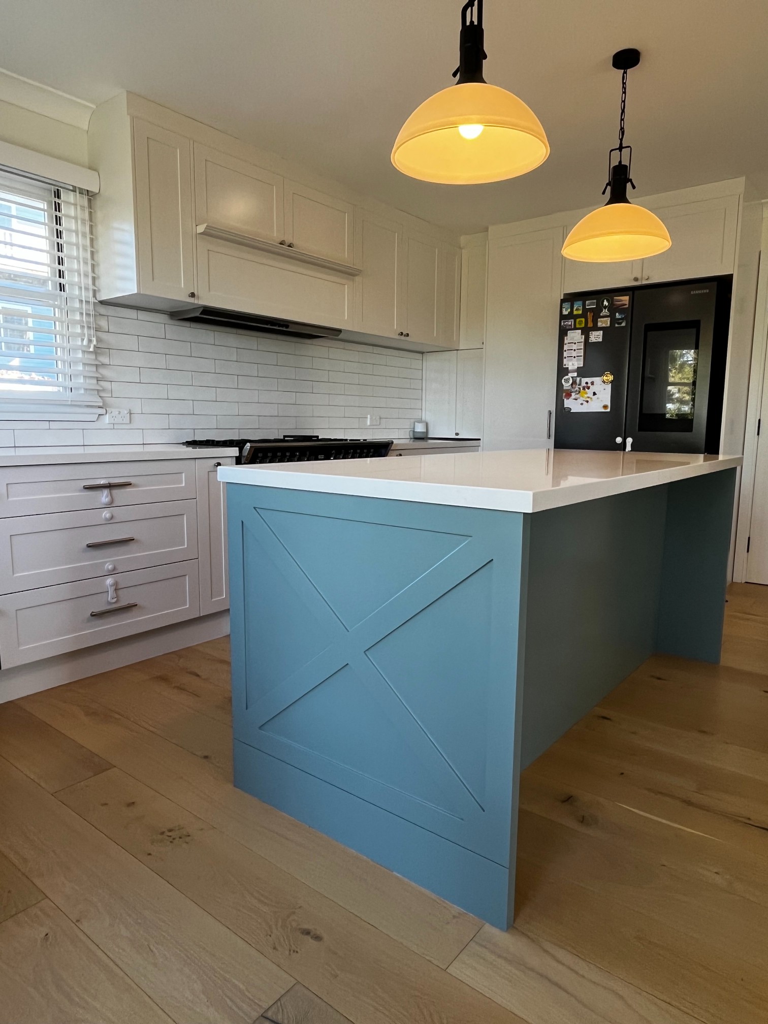 Custom Kitchen Design & Cabinetry: modern kitchen with white cabinets, blue island, and stainless appliances.