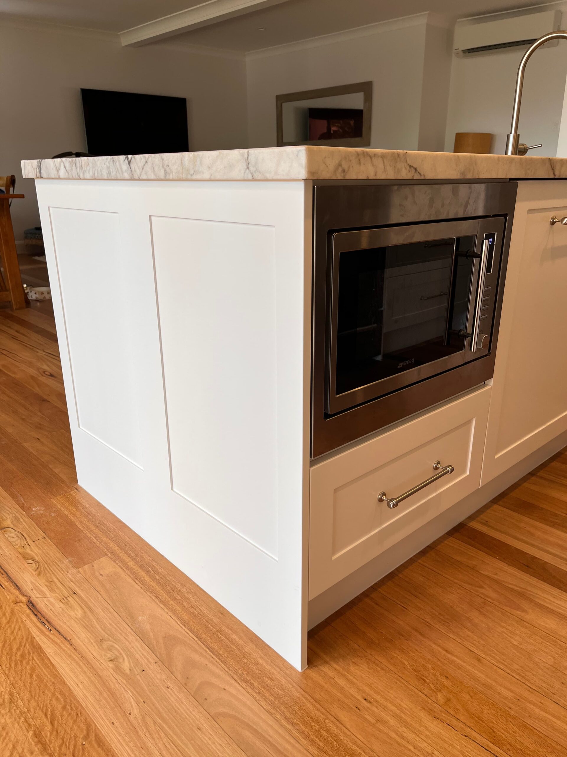 Modern kitchen island with white panel, marble countertop, wooden floor—Kitchen Renovation Collaroy Plateau.