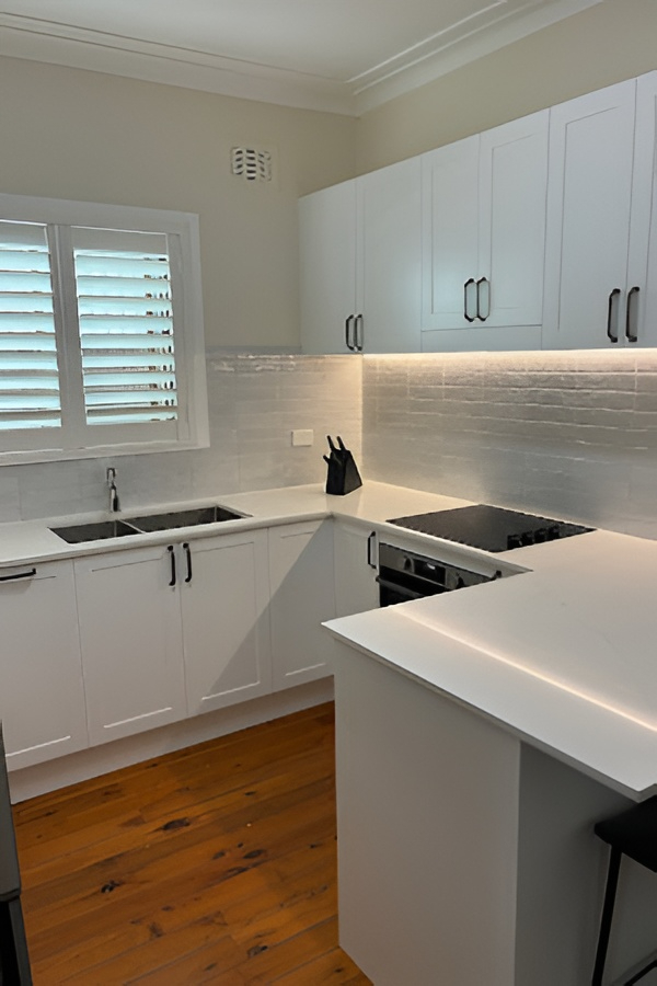 Modern kitchen by Red Hot Kitchens featuring white cabinets, custom construction, wood floor, window shutters.
