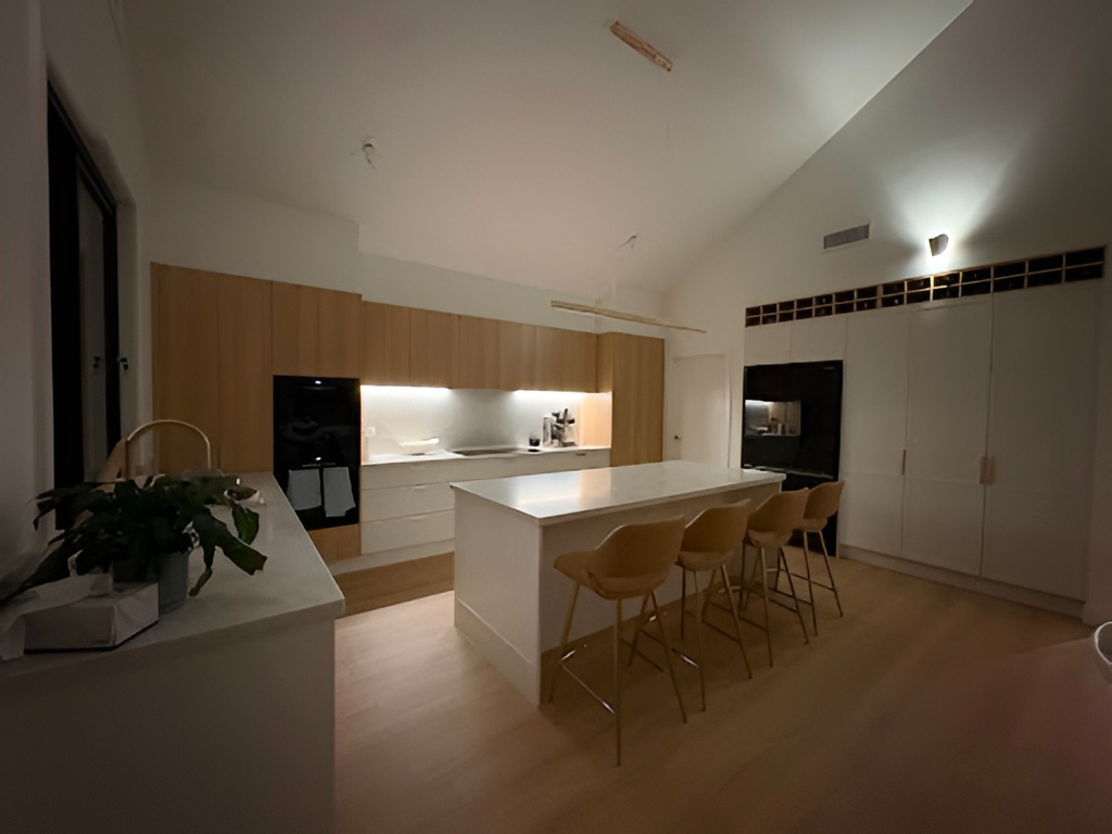 Modern kitchen by Red Hot Kitchens in North Curl Curl with wood cabinets, white countertops, island & built-ins.