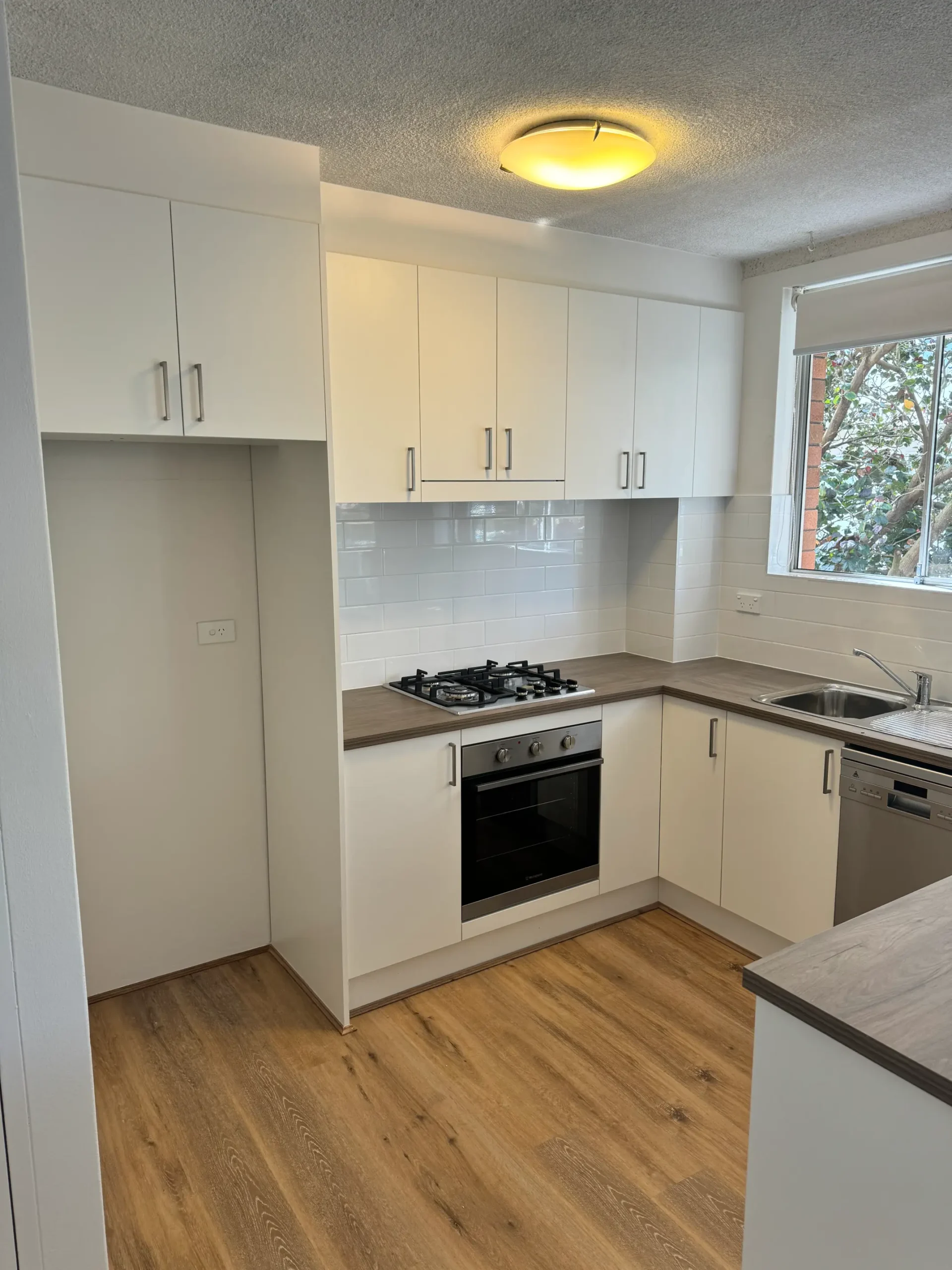 Freshwater kitchen door reface with white laminate doors, bar handles, gas cooktop and built-in oven